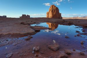 A large rock seen in a reflection at La Sal Mountains Viewpoint in Arches National Park, Utah